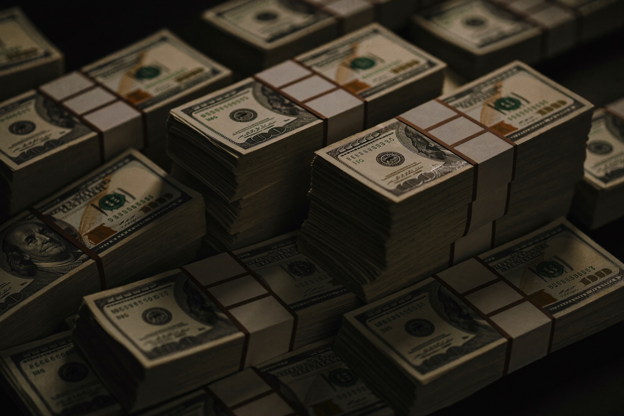 Banded stacks of prop movie money on a dark film set